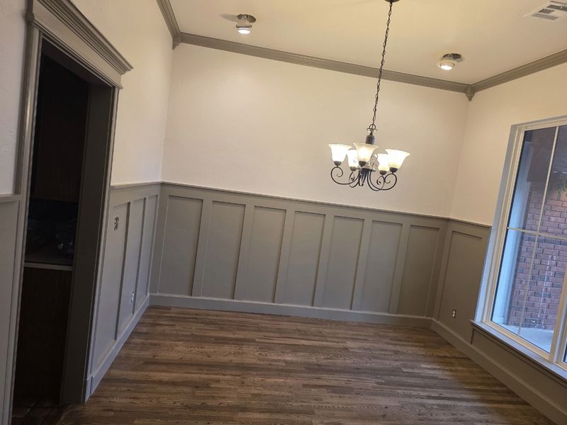 Dining room with new board and batten wainscoting, crown molding and hardwood floors